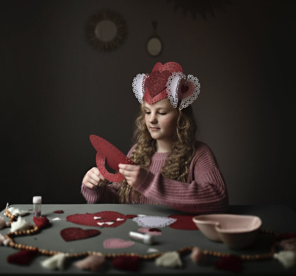 Valentine's Day Photography. Fine art photograph of little girl making Valentines.